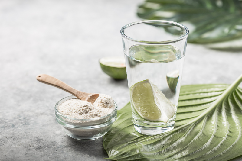 Collagen Powder and glass of water with slice of Lime
